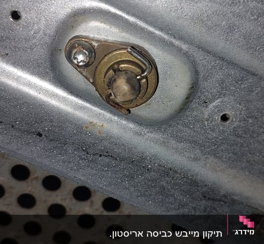 חלק מתכתי עם ברגים וחורים על משטח מתכת